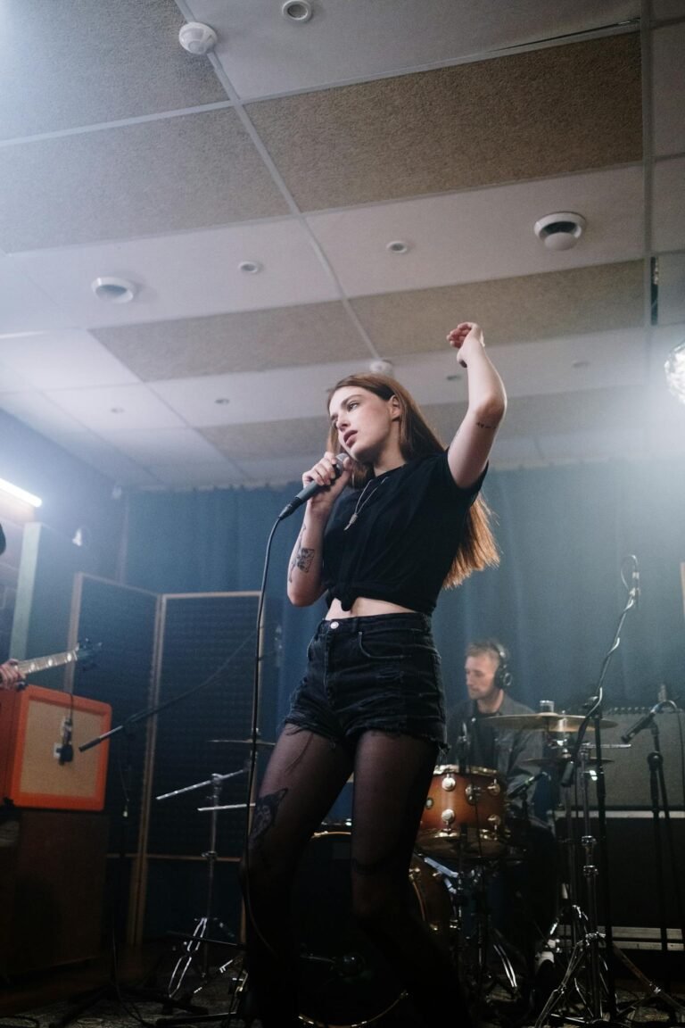 A dynamic live performance featuring a female singer in a studio setting with a live band.