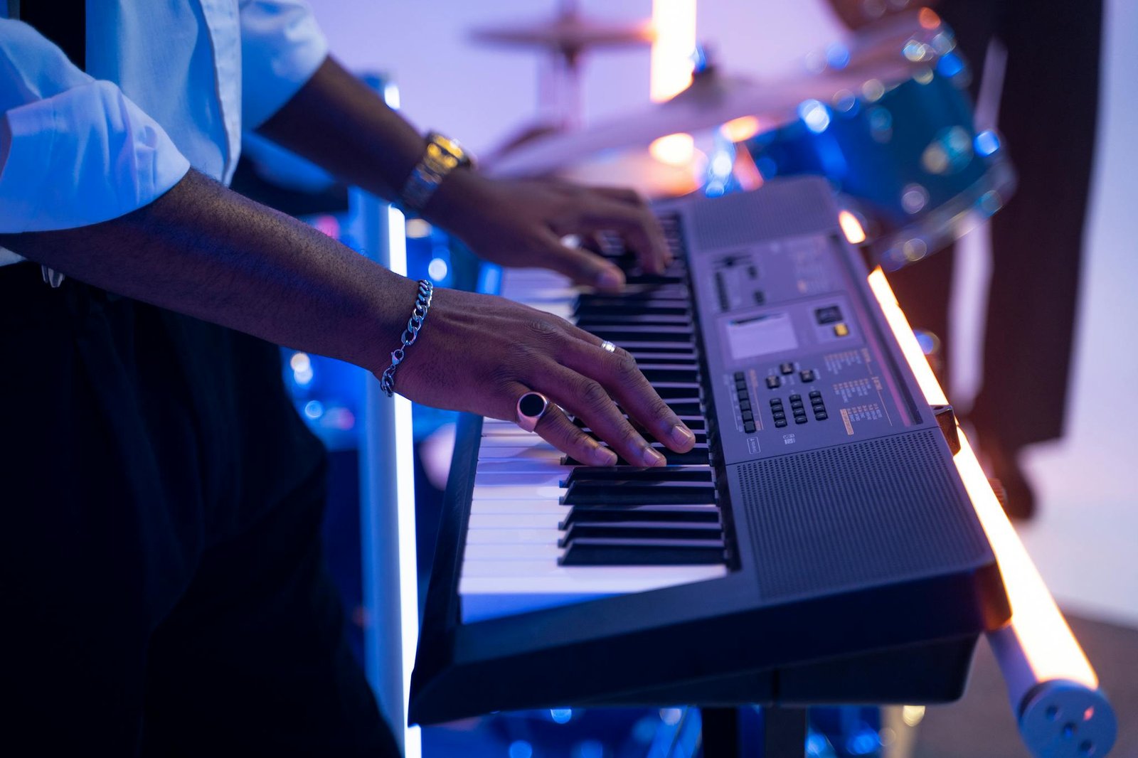 A musician playing an electronic keyboard on stage, showcasing live music performance energy.